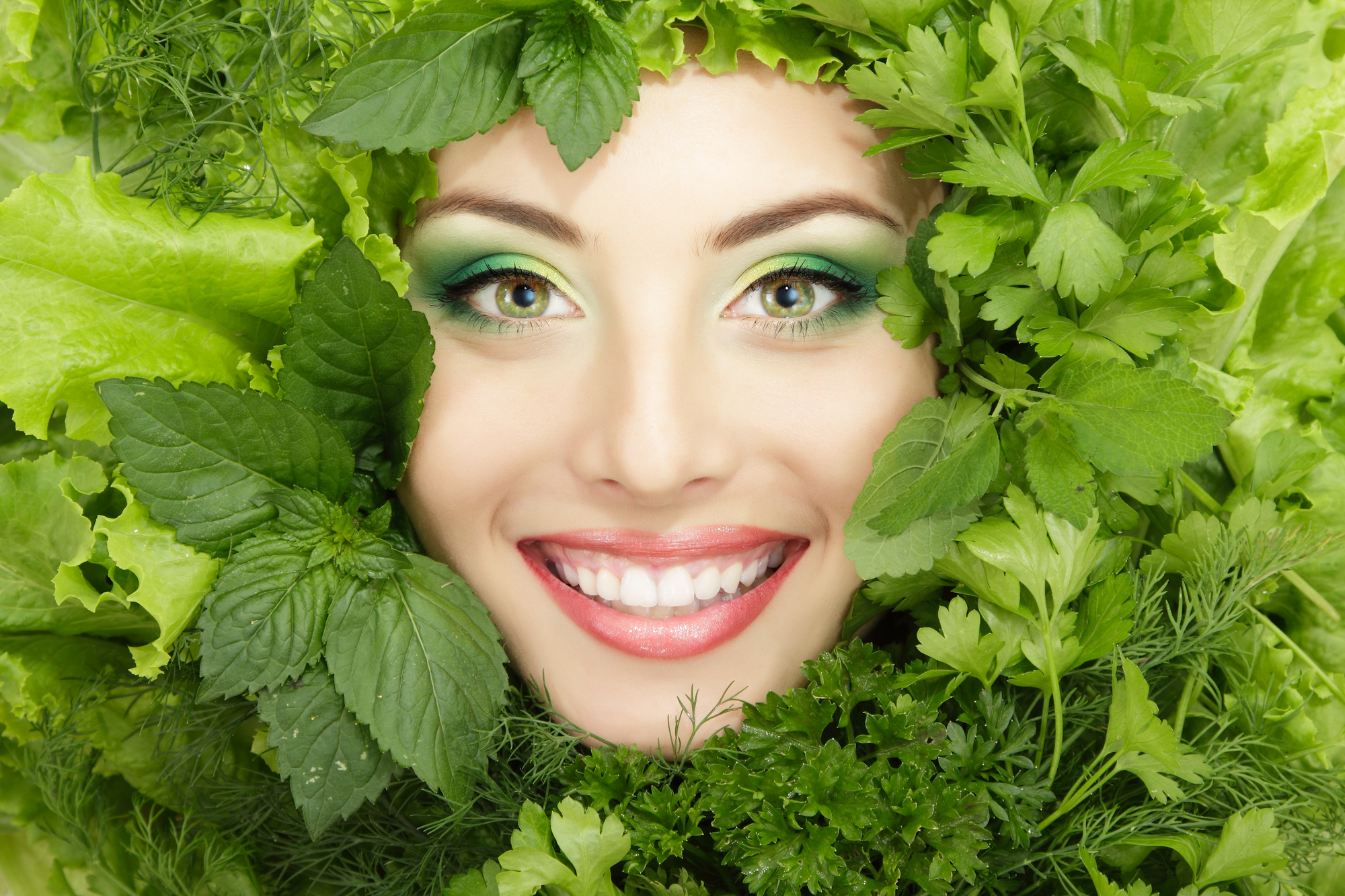 woman beauty face with greens vegetables frame isolated on white background