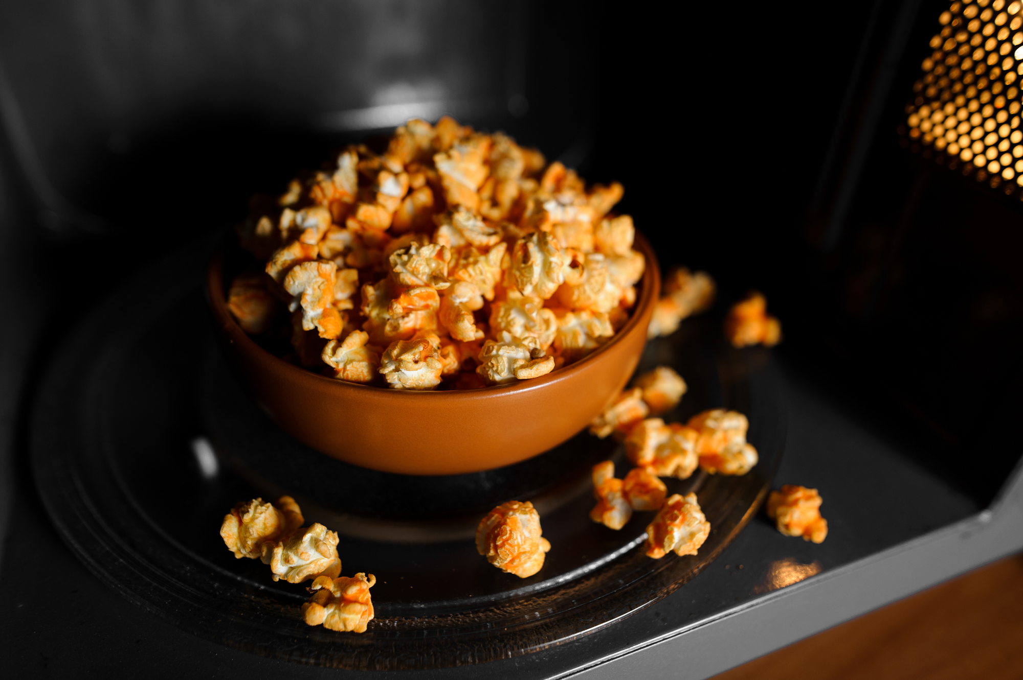 roasted popcorn in a clay brown dish stand in the microwave