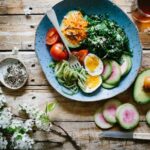 Nutrition - poached egg with vegetables and tomatoes on blue plate