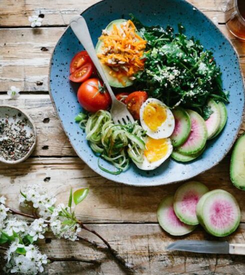 Nutrition - poached egg with vegetables and tomatoes on blue plate