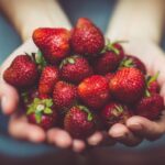 Nutrition - shallow focus photography of strawberries on person's palm