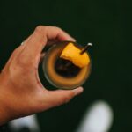 Nutrition - person holding black ceramic mug with yellow liquid