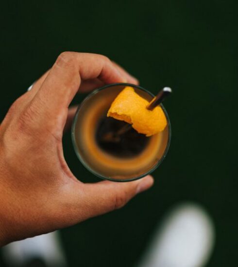 Nutrition - person holding black ceramic mug with yellow liquid