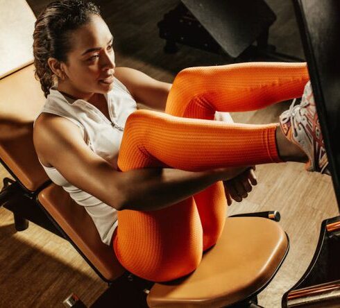 Diets - Woman in White Tank Top and Orange Pants Sitting on Black and Brown Chair