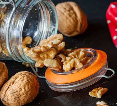 Superfoods - Walnuts in a jar with a knife and spoon