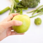 Superfoods - person's hand holding green apple