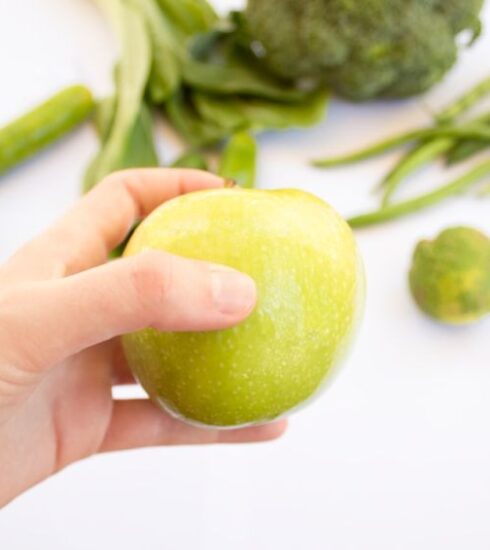 Superfoods - person's hand holding green apple