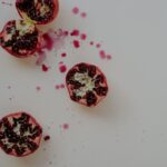 Superfoods - a cut open pomegranate on a white surface