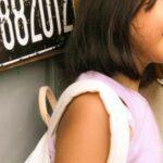 Foods - A young girl talking on the phone in front of a telephone booth