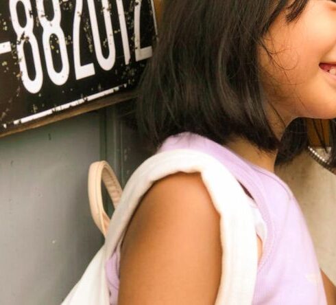 Foods - A young girl talking on the phone in front of a telephone booth