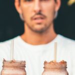 Diet - Man Wearing White Crew-neck T-shirt and Fitted Cap Holding Two Glass Jars