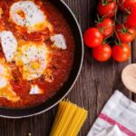 Cooking - Black Frying Pan With Spaghetti Sauce Near Brown Wooden Ladle and Ripe Tomatoes