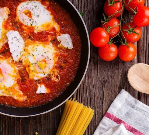 Cooking - Black Frying Pan With Spaghetti Sauce Near Brown Wooden Ladle and Ripe Tomatoes