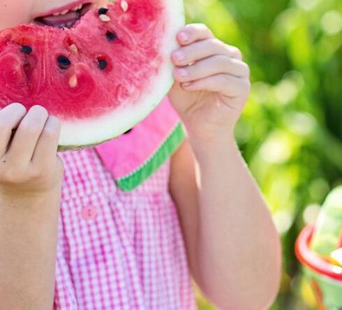 Healthy Eating - Girl Eating Sliced Watermelon Fruit Beside Table