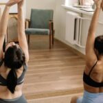 Sport Exercise - Woman in Black Sports Bra and Black Panty Doing Yoga on Blue Bed