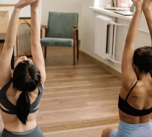 Sport Exercise - Woman in Black Sports Bra and Black Panty Doing Yoga on Blue Bed