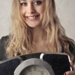 Weight Loss - Woman in Black Shirt Holding Black and Silver Weight Scale