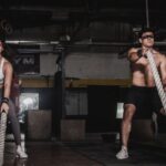 Workout - Man And Woman Holding Battle Ropes