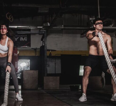 Workout - Man And Woman Holding Battle Ropes