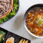 Meals - A table with bowls of noodles, rice and other food