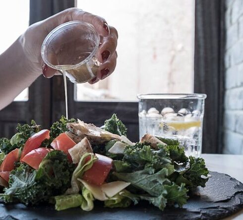 Diet - Person Pouring Dip on Vegetable Salad