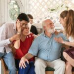 Family Gatherings - Man in Blue Dress Shirt Sitting Beside Woman in Pink Dress