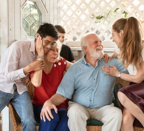 Family Gatherings - Man in Blue Dress Shirt Sitting Beside Woman in Pink Dress