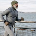 Elderly Athlete - Serious black man running on embankment