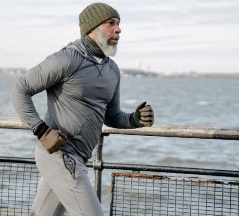 Elderly Athlete - Serious black man running on embankment