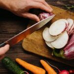 Wellness Diet - Person Slicing White Onion on Brown Wooden Chopping Board