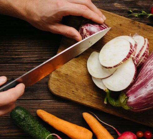 Wellness Diet - Person Slicing White Onion on Brown Wooden Chopping Board