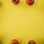 Diet - red tomato fruit on yellow background