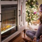 Holidays - woman in gray long sleeve shirt sitting on floor beside fireplace