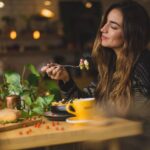 Eating - woman holding fork in front table