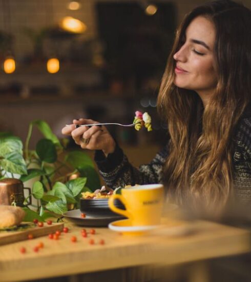 Eating - woman holding fork in front table