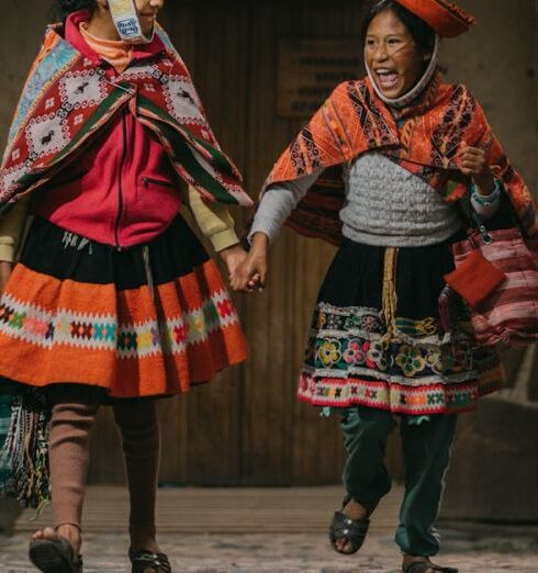 Skirts - Peruvian Girls Wearing Traditional Clothing, Posing by a Heritage Building