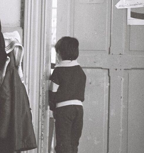 Coats - A child standing in front of a door