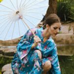 Kimonos - A woman in a kimono is standing on a bridge