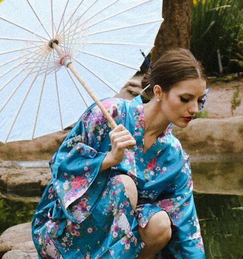 Kimonos - A woman in a kimono is standing on a bridge