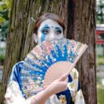 Kimonos - A woman in a geisha costume holding a fan