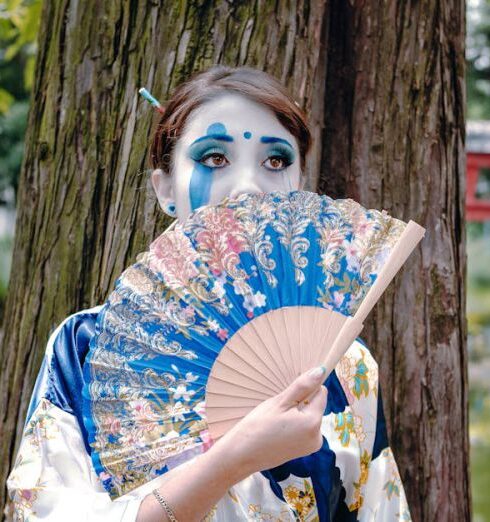 Kimonos - A woman in a geisha costume holding a fan