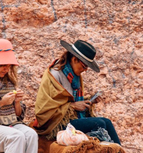 Ponchos - Women Sitting on Rock