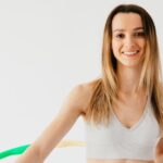 Weight Loss - Cheerful sportswoman exercising with hula hoop