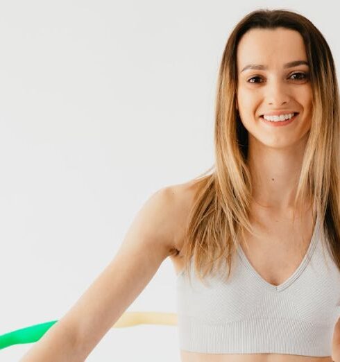 Weight Loss - Cheerful sportswoman exercising with hula hoop