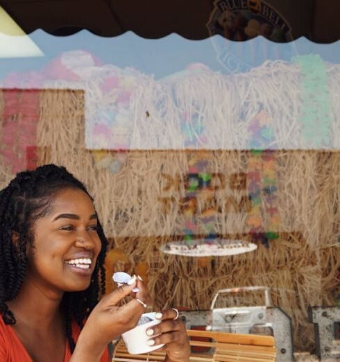 Eating - Woman Smiling and Eating Outside the Pop Porium Shop