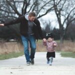 Parenting - A Father and his Little Girl Running on a Park Pathway