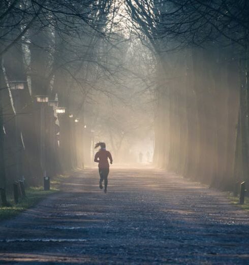 Exercise - Person Running Near Street Between Tall Trees