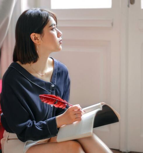 Mindfulness - Thoughtful woman writing in notebook at home