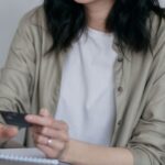 Spending - A Woman Holding a Credit Card Using a Laptop