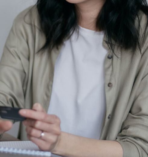 Spending - A Woman Holding a Credit Card Using a Laptop